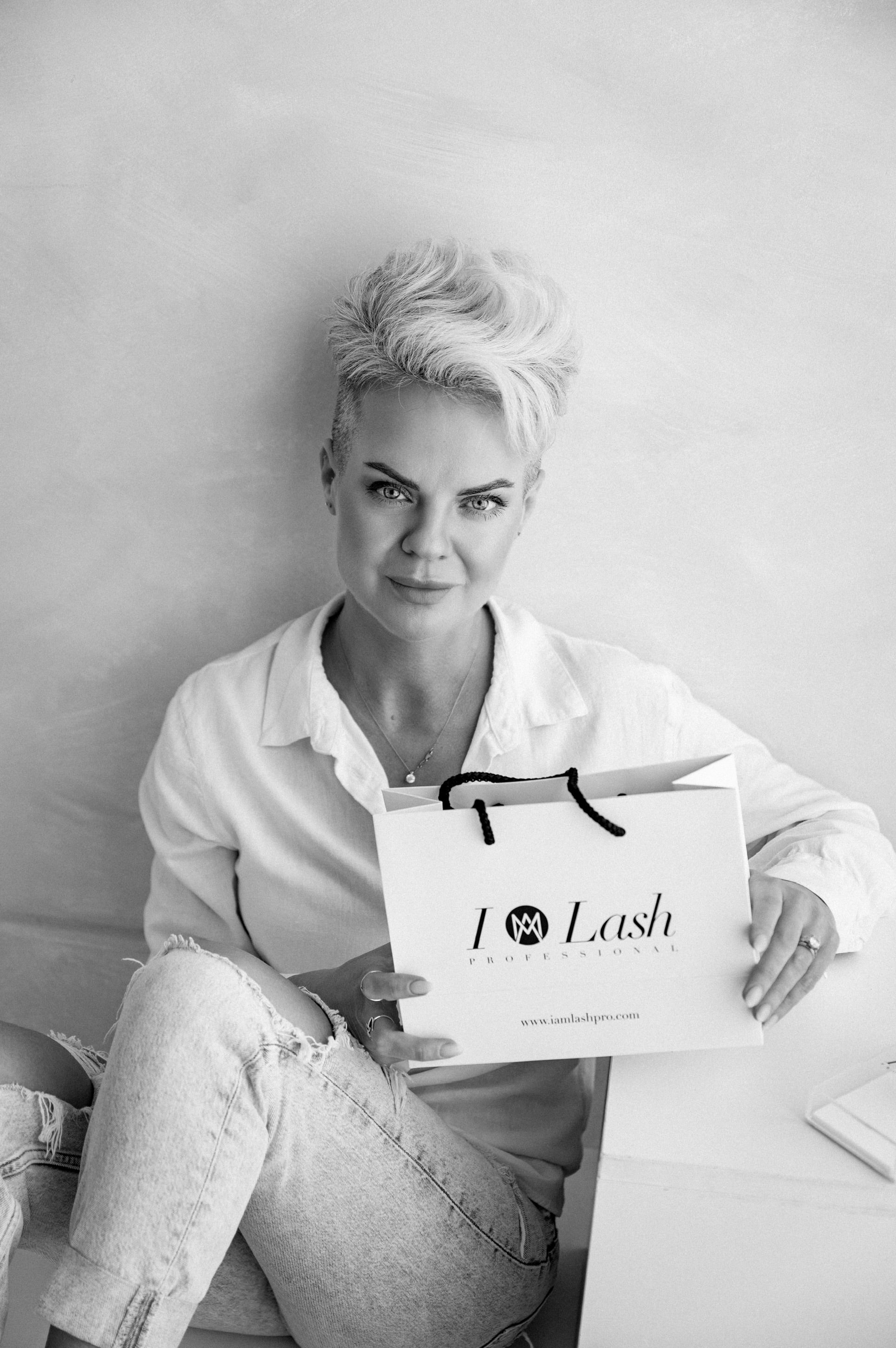 Arune Mooney founder of I AM Lash PRO holding branded shopping bag