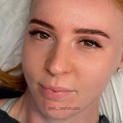 Close-up of soft, dark brown volume eyelash extensions with a fluffy, curled finish and subtly longer outer corners, framing hazel eyes.